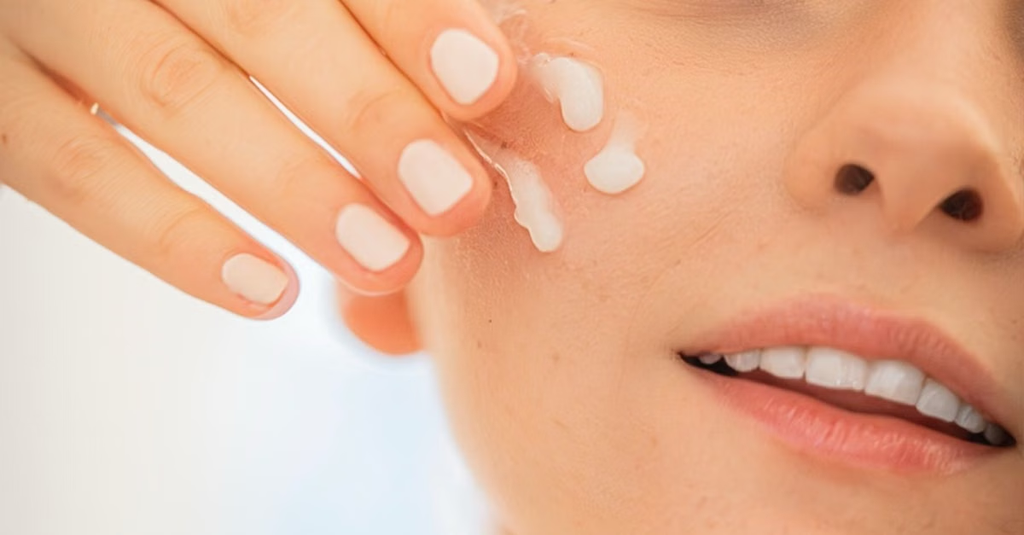 Woman applying moisturizer to prevent oily skin from overproducing oil